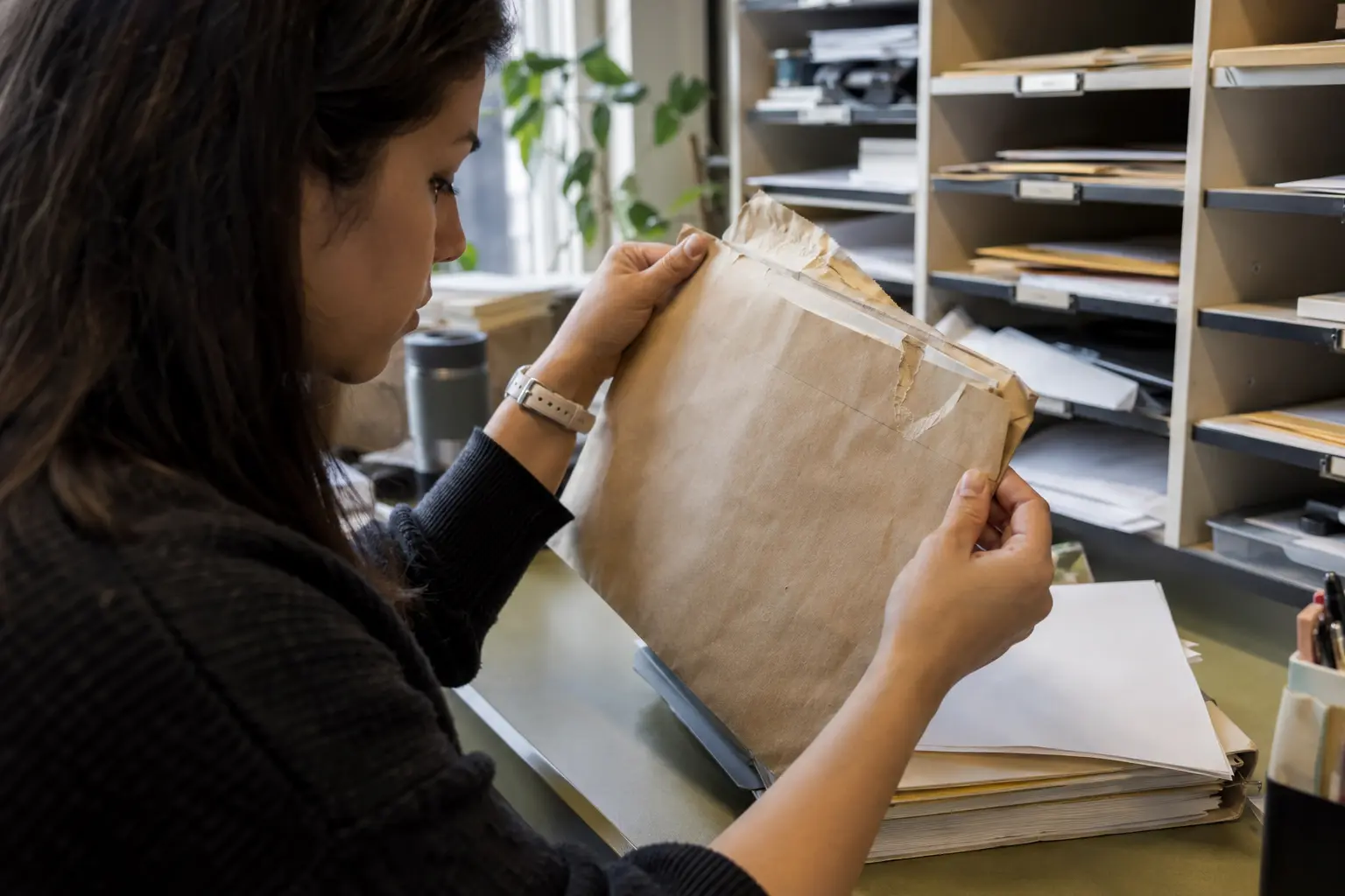 A paralegal inspects a returned envelope and filing packet.